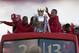 Manchester United's Nemanja Vidic, centre right, and Patrice Evra, centre left, hold the trophy on a bus outside Old Trafford Stadium as the team parade across Manchester after winning the English Premier League, Manchester, England, Monday May 13, 2013. Manager Alex Ferguson will retire at the end of the season after more than 26 years in charge at the club. (AP Photo/Jon Super)