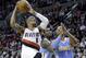 Portland Trail Blazers guard Damian Lillard, left, drives to the basket against Denver Nuggets' Randy Foye, right, and J.J. Hickson during the second half of an NBA basketball game in Portland, Ore., Saturday, March 1, 2014. Lillard scored 17 points as they beat the Nuggets 102-96. (AP Photo/Don Ryan)