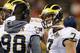 Michigan's Shane Morris (7) talks things over with injured quarterback Devin Gardner (98) during a timeout in the first half of the Buffalo Wild Wings Bowl NCAA college football game against Kansas State Saturday, Dec. 28, 2013, in Tempe, Ariz. (AP Photo/Ross D. Franklin)