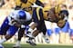 West Virginia running back Shawne Alston (20) is tackled by Kansas' Keon Stowers (98) during the first quarter of their NCAA college football game in Morgantown, W.Va., on Saturday, Dec. 1, 2012. West Virginia won 59-10. (AP Photo/Christopher Jackson)