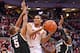 COLUMBUS, OH - MARCH 9: LaQuinton Ross #10 of the Ohio State Buckeyes splits the defense of Adreian Payne #5 of the Michigan State Spartans and Branden Dawson #22 of the Michigan State Spartans in the second half on March 9, 2014 at Value City Arena in Columbus, Ohio. Ohio State defeated Michigan State 69-67. (Photo by Jamie Sabau/Getty Images)