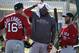 Boston Red Sox designated hitter David Ortiz, center, adjusts a towel on his head while talking with third baseman Will Middlebrooks, left, and second baseman Dustin Pedroia, right, during spring training baseball practice Tuesday, Feb. 18, 2014, in Fort Myers, Fla. (AP Photo/Steven Senne)