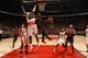 Bulls forward Jimmy Butler attempts an acrobatic shot over Raptors forward Patrick Patterson.