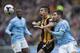 Hull City's Jake Livermore, centre, fights for the ball against Manchester City's Javier Garcia, right, during their English Premier League soccer match at the KC Stadium, Hull, England, Saturday March 15, 2014. (AP Photo/Jon Super)