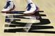 A players shoes are seen on the NCAA logo during Kansas' practice session for the NCAA Final Four basketball tournament Friday, March 30, 2012, in New Orleans. Kansas plays Ohio State in a semifinal game on Saturday. (AP Photo/Mark Humphrey)