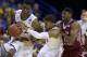 Kansas' Frank Mason, center, tries to hand a ball to teammate Andrew Wiggins, left, as Eastern Kentucky's Marcus Lewis watches during the first half of a second-round game in the NCAA college basketball tournament Friday, March 21, 2014, in St. Louis. (AP Photo/Jeff Roberson)