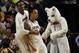Connecticut's Amidah Brimah (35) grabs Shabazz Napier (13) after his basket alongside their Huskies mascot during overtime of a second-round game against Saint Joseph's in the NCAA college basketball tournament in Buffalo, N.Y., Thursday, March 20, 2014. Connecticut won the game 89-81. (AP Photo/Bill Wippert)