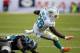 Nov 24, 2013; Miami Gardens, FL, USA; Miami Dolphins running back Lamar Miller (26) runs the ball as Carolina Panthers cornerback Melvin White (23) and strong safety Robert Lester (38) attempt the tackle in the second quarter of a game at Sun Life Stadium. Mandatory Credit: Robert Mayer-USA TODAY Sports