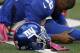New York Giants' Antrel Rolle (26) stretches by his helmet adorned with pink gloves helping bring attention to breast cancer awareness before an NFL football game against the Dallas Cowboys Sunday, Oct. 28, 2012, in Arlington, Texas. The Giants defeated the Cowboys 29-24. (AP Photo/Tony Gutierrez)
