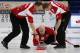 Canada's skip Kevin Koe, center, releases a stone as first Nolan Thiessen, left, and second Carter Rycroft sweep during their gold medal match against Norway, at the Curling World Championships, in Cortina D'Ampezzo, Italy, Sunday, April 11, 2010. Canada won the match. (AP Photo/Antonio Calanni)