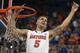 Florida guard Scottie Wilbekin (5) holds up a piece of the net after the Gators became the first team in Southeastern Conference history to go 18-0 in league pla, Saturday, March 8, 2014 in Gainesville, Fla. Florida defeated Kentucky 84-65 Saturday in an NCAA college basketball game. (AP Photo/Phil Sandlin)