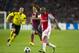 Ajax's Thulani Serero, front, vies for the ball with Barcelona's Carles Puyol during the Group H Champions League soccer match between Ajax and FC Barcelona at the ArenA stadium in Amsterdam, Netherlands, Tuesday Nov. 26, 2013. (AP Photo/Patrick Post)