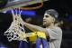Florida guard Scottie Wilbekin cuts part of the net after the second half in a regional final game against Dayton at the NCAA college basketball tournament, Saturday, March 29, 2014, in Memphis, Tenn. Florida won 62-52. (AP Photo/Mark Humphrey)