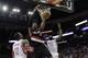 Portland Trail Blazers forward LaMarcus Aldridge (12) dunks between Houston Rocket's Dwight Howard (12) and James Harden (13) during the first half of an NBA basketball game, Monday, Jan. 20, 2014, in Houston. (AP Photo/Bob Levey)