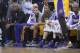 Los Angeles Lakers shooting guard Kobe Bryant, left, watches from the end of the bench as a teammate takes a shot during the first half of an NBA basketball game against the Orlando Magic in Orlando, Fla., Friday, Jan. 24, 2014.(AP Photo/Phelan M. Ebenhack)