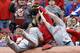 St. Louis Cardinals first baseman Matt Adams falls into the stands while trying to catch a foul ball hit by Cincinnati Reds' Chris Heisey that was caught by a fan in the third inning of a baseball game on Thursday, April 3, 2014, in Cincinnati. (AP Photo/Al Behrman)
