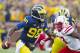 Michigan quarterback Devin Gardner (98) scrambles around Nebraska linebacker Zaire Anderson (13) in the first quarter of an NCAA college football game in Ann Arbor, Mich., Saturday, Nov. 9, 2013. (AP Photo/Tony Ding)