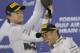 Mercedes driver Nico Rosberg of Germany, left, second place, sprays rose water to the winner teammate Mercedes driver Lewis Hamilton of Britain on the podium after the Bahrain Formula One Grand Prix at the Bahrain International Circuit in Sakhir, Bahrain, Sunday, April 6, 2014. (AP Photo/Luca Bruno)