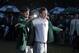 Bubba Watson, left, helps Adam Scott, of Australia, put on his green jacket after winning the Masters golf tournament Sunday, April 14, 2013, in Augusta, Ga. (AP Photo/Charlie Riedel)