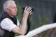 Trainer Todd Pletcher leans on the outside rail to watch his horses gallop on the track at Belmont Park during a morning workout Thursday, June 6, 2013 in Elmont, N.Y. Pletcher has five horses entered in Saturday's Belmont Stakes horse race. (AP Photo/Mark Lennihan)