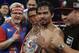 Manny Pacquiao, of the Philippines, center, is joined by trainer Freddie Roach, left, as he poses with the champion's belt following his unanimous decision against Timothy Bradley in their WBO welterweight title boxing fight Saturday, April 12, 2014, in Las Vegas. (AP Photo/Isaac Brekken)