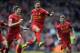 Liverpool's Philippe Coutinho, centre, celebrates with teammate Steven Gerrard, left, after he scored the third goal of the game for his side during their English Premier League soccer match against Manchester City at Anfield in Liverpool, England, Sunday April. 13, 2014. (AP Photo/Clint Hughes)