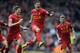 Liverpool's Philippe Coutinho, centre, celebrates with teammate Steven Gerrard, left, after he scored the third goal of the game for his side during their English Premier League soccer match against Manchester City at Anfield in Liverpool, England, Sunday April. 13, 2014. (AP Photo/Clint Hughes)