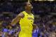 Michigan's Glenn Robinson III walks off the court as Kentucky players celebrate after an NCAA Midwest Regional final college basketball tournament game Sunday, March 30, 2014, in Indianapolis. Kentucky won 75-72 to advance to the Final Four. (AP Photo/Michael Conroy)