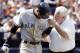 New York Yankees shortstop Derek Jeter grimaces after being hit in the elbow with a pitch in the sixth inning against the New York Mets as he walks with assistant coach Steve Donahue at Shea Stadium in New York Saturday, May21, 2005. (AP Photo/Gregory Bull)