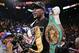 Floyd Mayweather Jr. holds up his title belts after defeating Canelo Alvarez during a 152-pound title fight, Saturday, Sept. 14, 2013, in Las Vegas. (AP Photo/Eric Jamison)