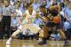Pittsburgh's Chris Jones (12) is challenged by North Carolina's J.P. Tokoto (13) during the first half of an NCAA college basketball game in Chapel Hill, N.C., Saturday, Feb. 15, 2014. (AP Photo/Karl B DeBlaker)