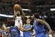 Memphis Grizzlies guard Tony Allen (9) shoots against Dallas Mavericks defenders Devin Harris (20); Dirk Nowitzki, rear, of Germany; and Jae Crowder (9) in the second half of an NBA basketball game Wednesday, April 16, 2014, in Memphis, Tenn. The Grizzlies won in overtime, 106-105. (AP Photo/Lance Murphey)
