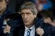 Manchester City's manager Manuel Pellegrini takes to the touchline before his team's English Premier League soccer match against Manchester United at Old Trafford Stadium, Manchester, England, Tuesday, March 25, 2014. (AP Photo/Jon Super)