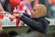 Munich head coach Pep Guardiola signs an autograph prior to the German soccer cup, DFB Pokal, semifinal match between FC Bayern Munich and FC Kaiserslautern in the Allianz Arena in Munich, Germany, on Wednesday, April 16. 2014. (AP Photo/Kerstin Joensson)