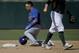 Oakland Athletics second baseman Eric Sogard, righrt, walks off after tagging out Chicago Cubs' Javier Baez stealing during the second inning of a baseball game in Phoenix, Monday, March 17, 2014. (AP Photo/Chris Carlson)