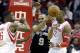 San Antonio Spurs' Tony Parker (9) passes the ball off under pressure from Houston Rockets Dwight Howard (12) and Terrence Jones (6) in the first half of an NBA basketball game Monday, April 14, 2014, in Houston. (AP Photo/Pat Sullivan)