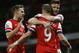 Arsenal's Lukas Podolski, center, celebrates scoring a goal with teammates Aaron Ramsey, left, and Olivier Giroud, right, during the English Premier League soccer match between Arsenal and West Ham United at the Emirates stadium in London, Tuesday, April 15, 2014. (AP Photo/Kirsty Wigglesworth)