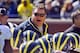 Michigan head coach Brady Hoke, center top, huddles with his players during the football team's NCAA college spring football game, Saturday, April 5, 2014, in Ann Arbor, Mich. (AP Photo/Tony Ding)