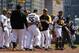 Pittsburgh Pirates' Russell Martin (55) is restrained by teammate Gaby Sanchez, center, as they walk to the dugout with manager Clint Hurdle, right, after a brawl between the Pittsburgh Pirates and the Milwaukee Brewers during the third inning of a baseball game in Pittsburgh Sunday, April 20, 2014. Brewers' Carlos Gomez and Pirates' Travis Snider were ejected from the game. (AP Photo/Gene J. Puskar)