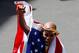 Apr 21, 2014; Boston, MA, USA; Meb Keflezighi (USA) pumps his fist while wearing an American flag at the finish line after winning the men's division of the 2014 Boston Marathon. Mandatory Credit: Greg M. Cooper-USA TODAY Sports