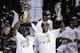 The Miami Heat's Dwyane Wade, left, holds the Larry O'Brien NBA Championship Trophy as LeBron James holds his Bill Russell NBA Finals Most Valuable Player Award after Game 7 of the NBA basketball championship against the San Antonio Spurs, Friday, June 21, 2013, in Miami. The Miami Heat defeated the San Antonio Spurs 95-88 to win their second straight NBA championship. The Miami Heat's Chris Bosh celebrates in the background. (AP Photo/Wilfredo Lee)