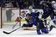 St. Louis Blues' T.J. Oshie, front, reaches for a puck to score past Chicago Blackhawks goalie Corey Crawford during the second period in Game 5 of a first-round NHL hockey playoff series Friday, April 25, 2014, in St. Louis. (AP Photo/Jeff Roberson)