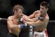 Urijah Faber, left, trades punches with Dominick Cruz during the first round of their UFC bantamweight mixed martial arts title match, Saturday, July 2, 2011 at The MGM Grand Garden Arena in Las Vegas. Cruz won by unanimous decision. (AP Photo/Eric Jamison)