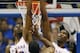 Iona guard Sean Armand (22) shoots over Kansas guard Andrew Wiggins (22) and center Joel Embiid (21) during the first half of an NCAA college basketball game at Allen Fieldhouse in Lawrence, Kan., Tuesday, Nov. 19, 2013. Kansas defeated Iona 86-66. (AP Photo/Orlin Wagner)