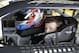 NASCAR driver Kasey Kahne waits in his garage while crew member make adjustments to his car during Sprint Cup auto racing testing at Daytona International Speedway in Daytona Beach, Fla., Friday, Jan. 10, 2014.(AP Photo/John Raoux)