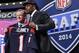 Jadeveon Clowney, defensive end de Carolina del Sur, sostiene un jersey de los Texans de Houston luego de ser la primera selección del draft de la NFL. A su lado el comisionado de la liga, Roger Goodell, el jueves 8 de mayo de 2014. (Foto AP/Craig Ruttle)