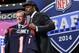 Jadeveon Clowney, defensive end de Carolina del Sur, sostiene un jersey de los Texans de Houston luego de ser la primera selección del draft de la NFL. A su lado el comisionado de la liga, Roger Goodell, el jueves 8 de mayo de 2014. (Foto AP/Craig Ruttle)