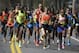 Ryan Hall, of Redding, Calif., center, runs near Meb Keflezighi, of San Diego, Calif., front right, along the route of the 118th Boston Marathon, Monday, April 21, 2014. (AP Photo/Steven Senne)