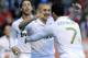 Real Madrid's Karim Benzema from France, center, is congratulated by his fellow teammate Cristiano Ronaldo from Portugal , right, after he scored against Osasuna, during their Spanish La Liga soccer match, at Reyno de Navarra stadium in Pamplona, northern Spain, Saturday March 31, 2012. (AP Photo/Alvaro Barrientos)