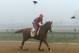 BALTIMORE, MD - MAY 15: Exercise rider Willie Delgado takes Kentucky Derby winner California Chrome over the track in preparation for the 139th Preakness Stakes at Pimlico Race Course on May 15, 2014 in Baltimore, Maryland. (Photo by Patrick Smith/Getty Images)